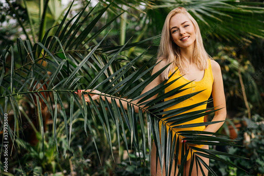 Woman in swimsuit on tropical plants background Woman in swimsuit on tropical plants background