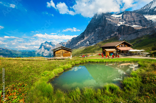 Small pond with wooden huts in the mountains, Grindelwald, Switzerland