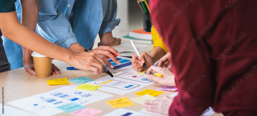 Close up ux developer and ui designer brainstorming about mobile app interface wireframe design on table with customer brief and color code at modern office.Creative digital development agency.panning - obrazy, fototapety, plakaty 
