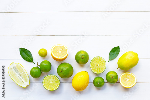 Ripe lemons and limes on white wooden.