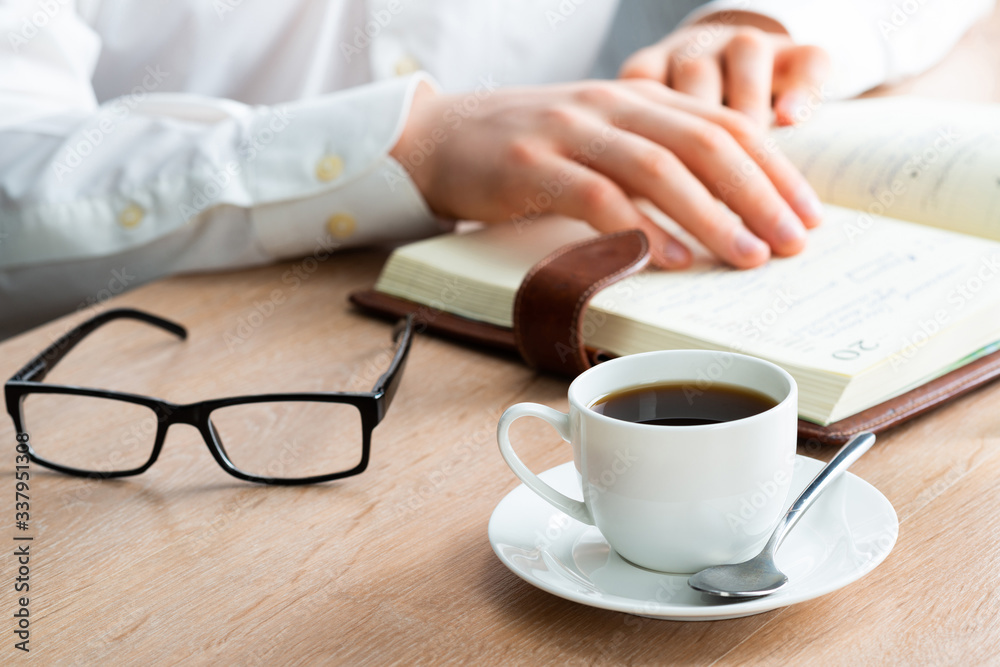 Man in white shirt reading notes in notebook Man in white shirt reading notes in notebook