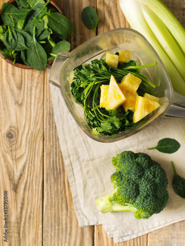 Ingrediets for green smoothie - parsley, spinach, broccoli and celery on wooden table photo