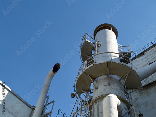 Bright air separation plant pipes and lanterns at bright sunny day over clear deep blue sky background with copy space. photo