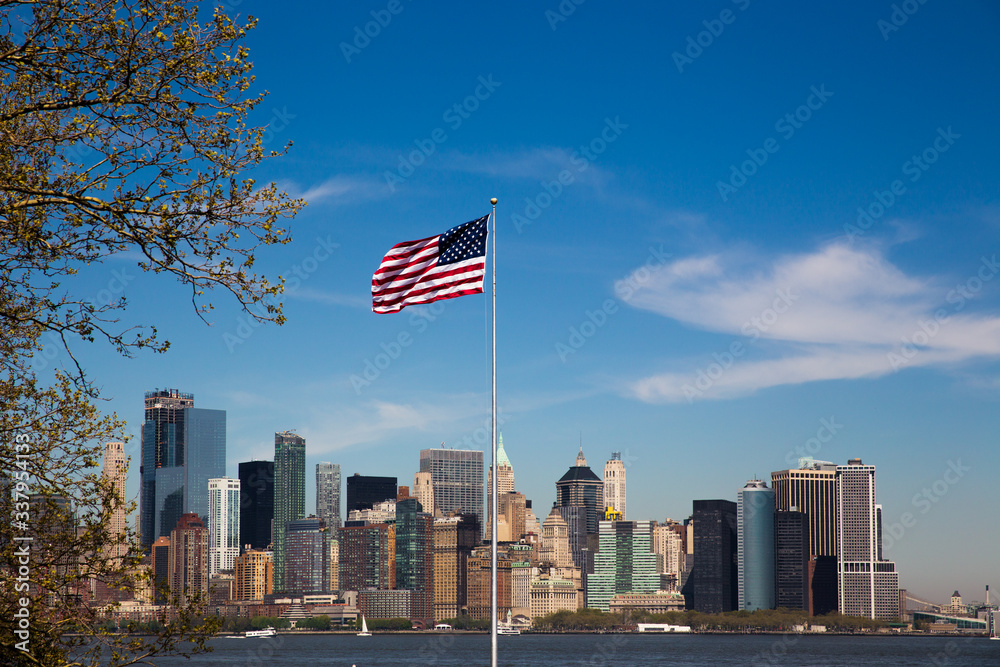 New York, USA - view on Manhattan from Ellis island with US flag