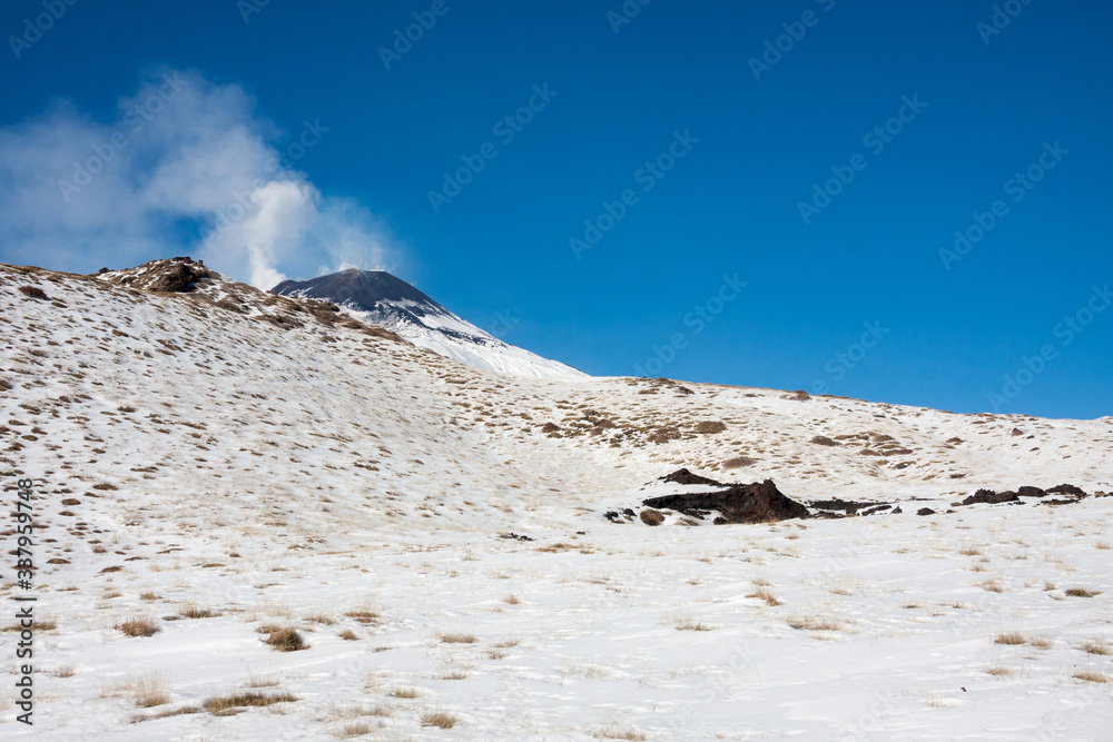 Mount Etna with snow, The active volcano with smoke and ash is coming from the crater. Etna National Park, Sicily, Italy