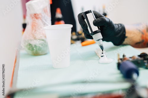 Female tattooist preparing the dyes she's going to work with.