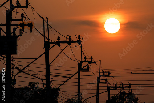 The sunrise above silhouette the electricity pole