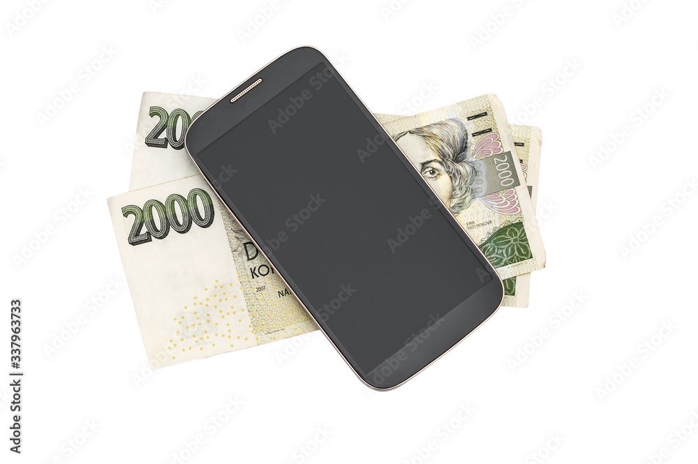 Fotografie Smartphone with czech krona bills on white.