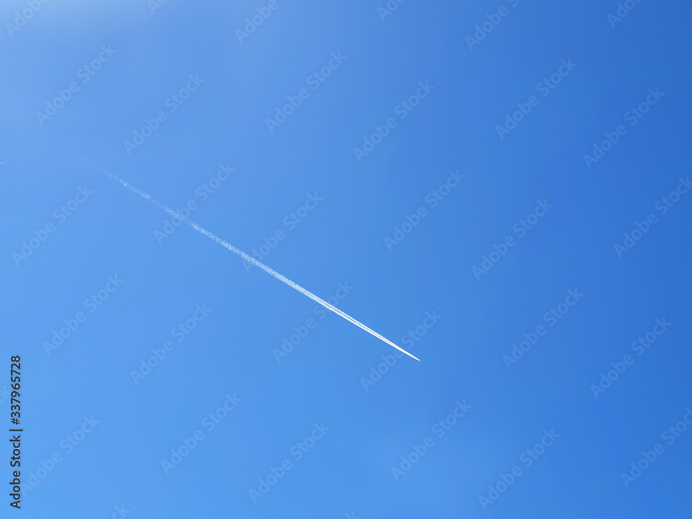 The white path of aircraft in the blue clear sky. The white path of aircraft in the blue clear sky.