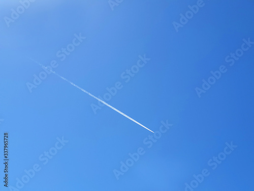 The white path of aircraft in the blue clear sky.