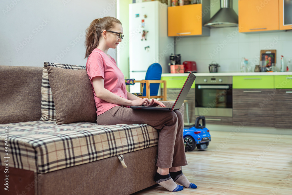 Woman remotely works on a laptop. Distance work and online education. Useful pastime when have to stay at home