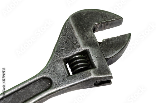 Large adjustable wrench on a white background. Insulated object. Old worn tool for mechanic. Metal texture close-up.
