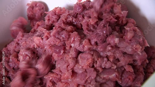 Pieces of red minced meat pile up in white container, closeup in butchery photo