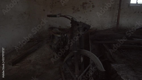 Chernobyl Exclusion Zone. Abandoned motorcycle in Cowshed on Farm in Mashevo Village. Wide Dolly Shot photo