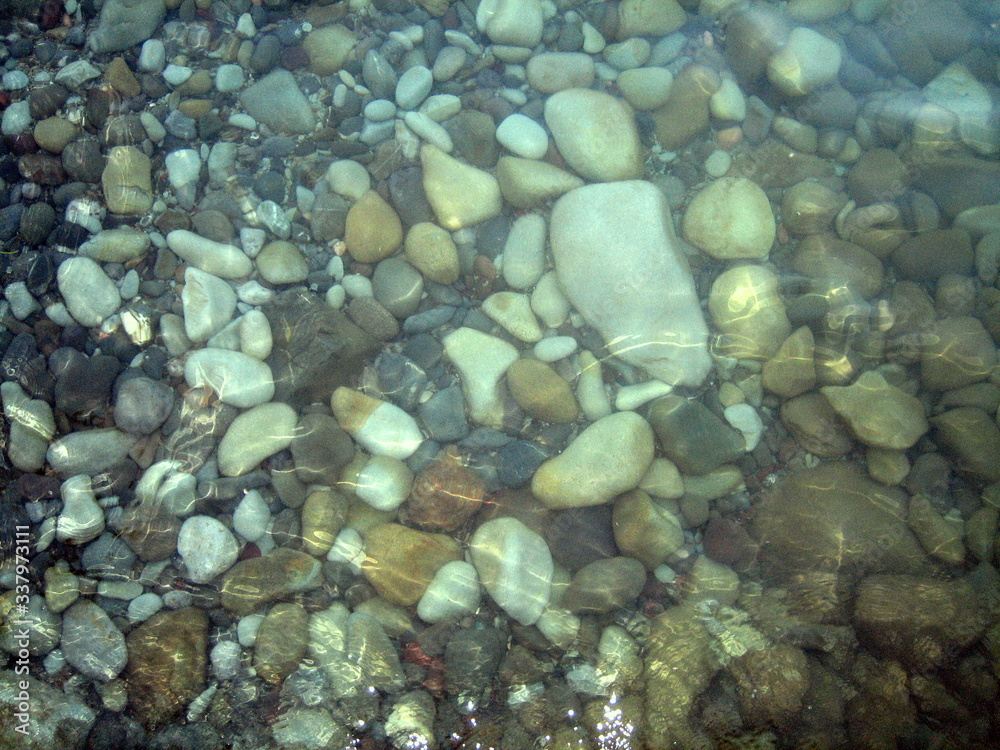Pebbles, rocks, seaweed on the sea floor through clear water in shallow water. Pebbles, rocks, seaweed on the sea floor through clear water in shallow water.