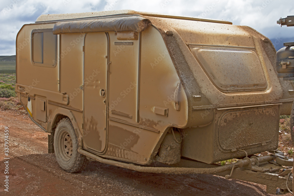 Off road caravan covered in fine mud
