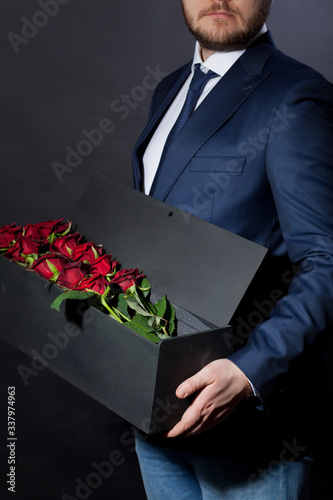 man gives red roses in an original box to his beloved woman