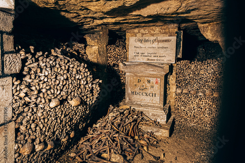underground catacombs full of bones, gravestones and inscriptions photo