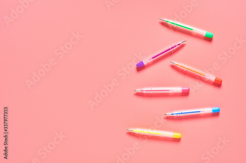 Workplace with colorful pens on pink countertop. Business or back to school concept. Secretaries workspace. Top view. Flat lay. Copy space