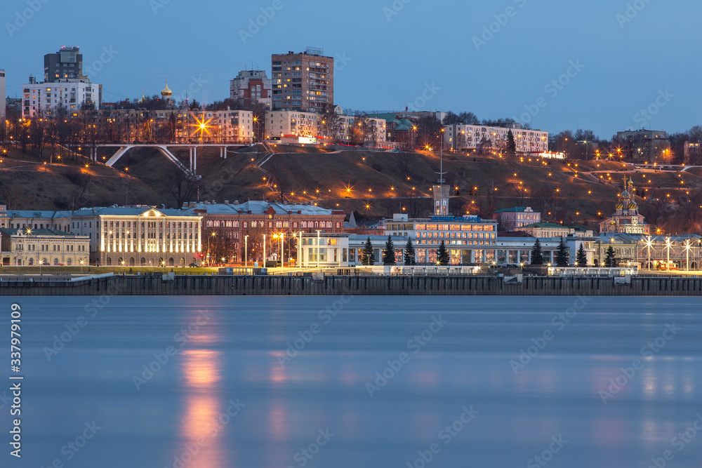 Fototapeta premium A unique perspective of Nizhny Novgorod in the evening with the city lights on against the backdrop of a beautiful sky and sunset