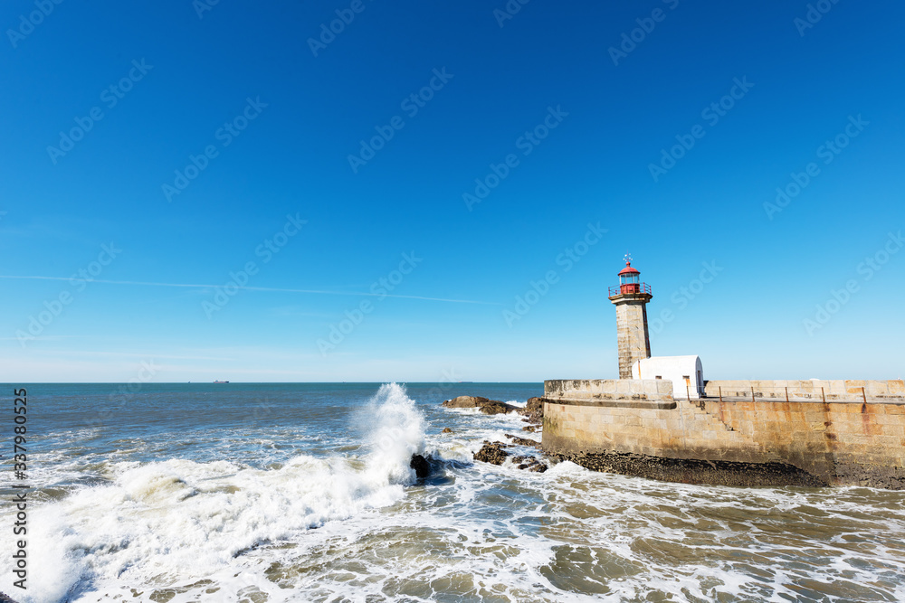 Lighthouse and waving ocean.Copy space, wind angle