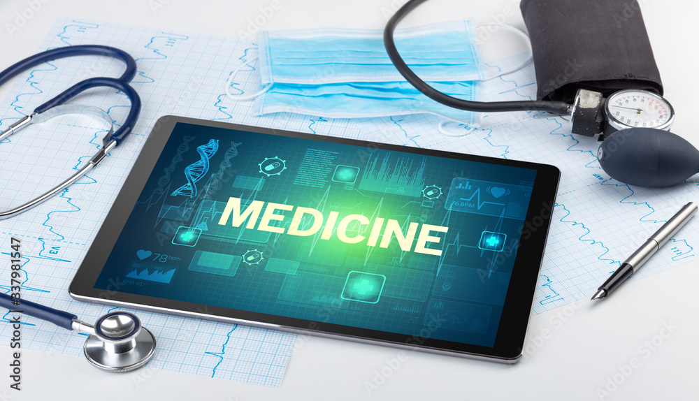 Tablet pc and medical stuff with MEDICINE inscription, prevention concept