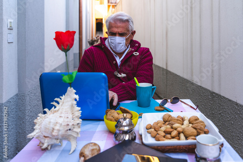 adult man is having breakfast while working on the computer outdoors
