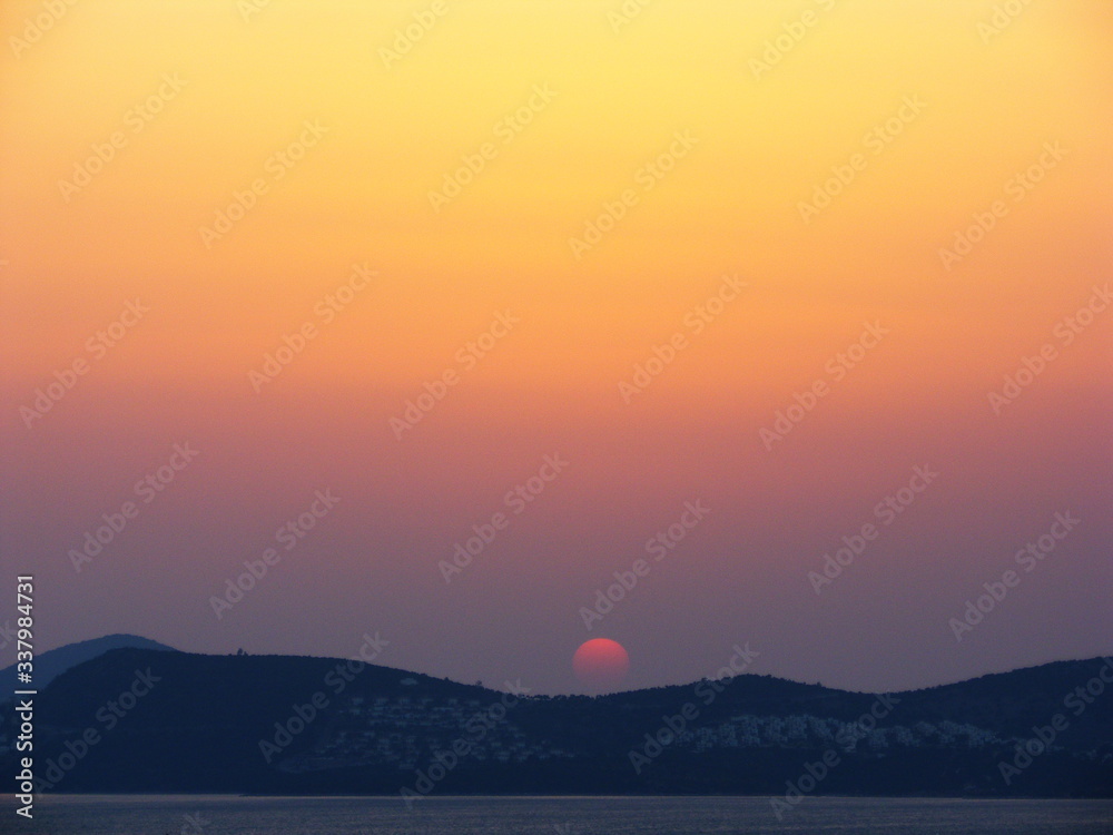 Sun is going down painting the sky in orange colour on Aegean Sea