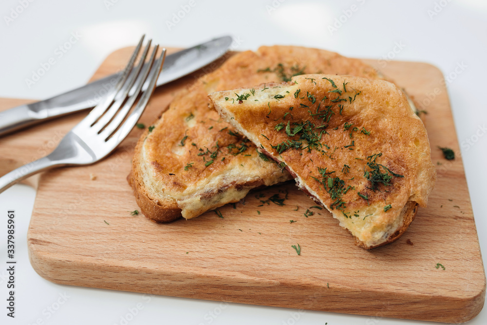 Toast with egg. Birmingham eggs on wooden plate, fork and knife Toast with egg. Birmingham eggs on wooden plate, fork and knife