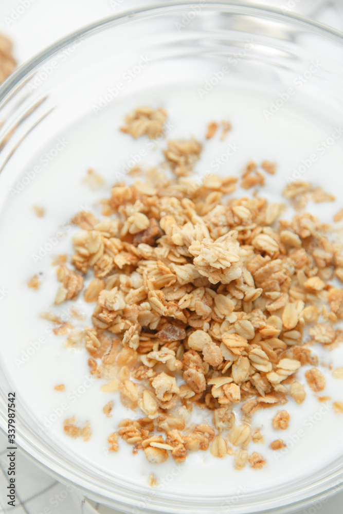Porridge flakes in a bowl with milk. Granola for Breakfast with yogurt and walnuts.