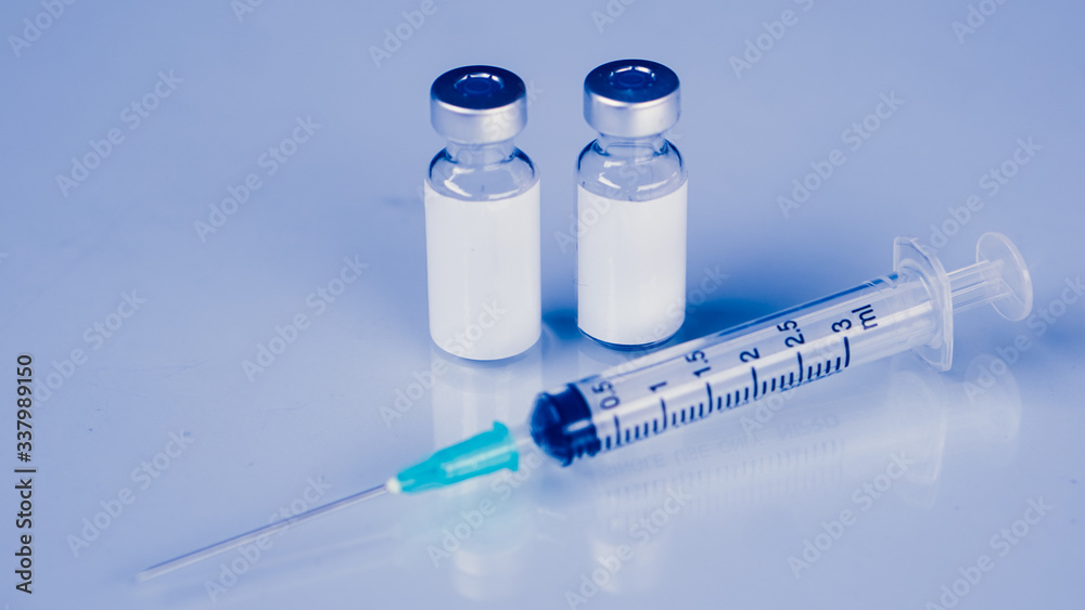 Vaccine vial dose flu shot drug needle syringe,medical concept . blue background. selection focus.Vaccine vial dose flu shot drug needle syringe,medical concept . blue background. selection focus. Vaccine vial dose flu shot drug needle syringe,medical concept . blue background. selection focus.Vaccine vial dose flu shot drug needle syringe,medical concept . blue background. selection focus.