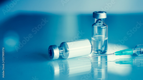 Vaccine vial dose flu shot drug needle syringe,medical concept . blue background. selection focus.