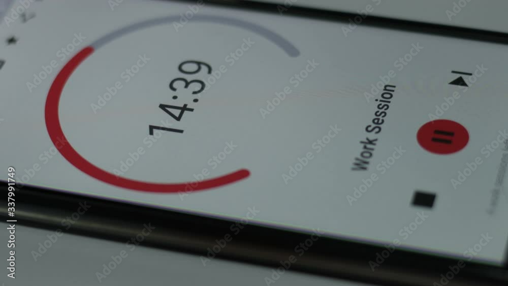Demonstration of Pomodoro Technique Time Management App. Hands to start the tomato timer on the smartphone screen. Used to improve the job
