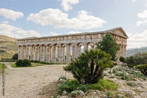 Ancient Doric temple of Segesta hidden behind the trees in nice sunny spring day in Sicily