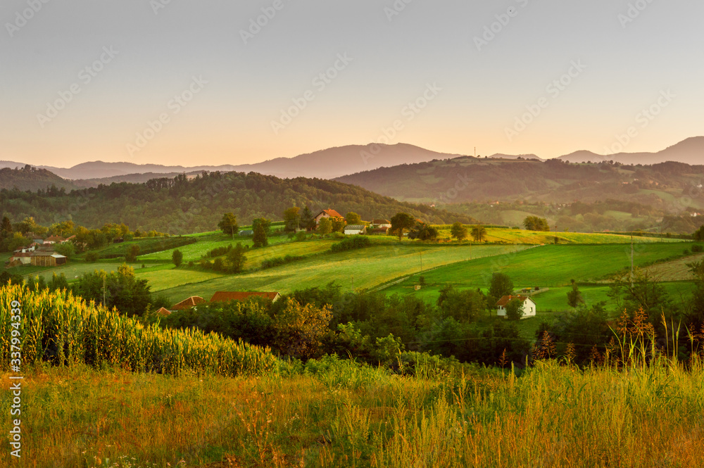 Mountain village in summer evening. Farm in Serbia, Europe. Fields and forest.