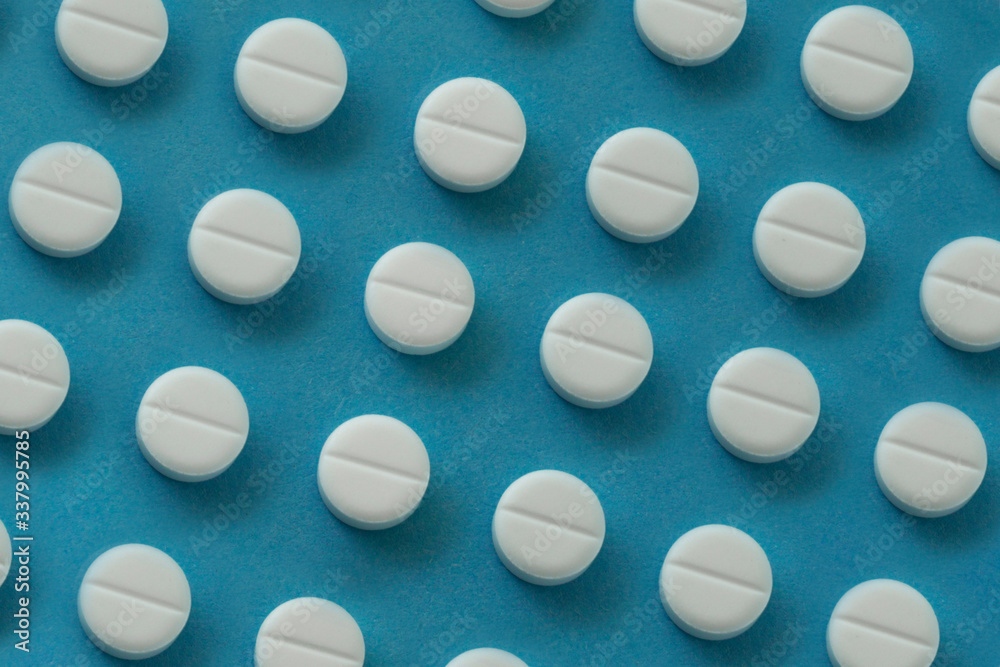 many white pills on plue background many white pills on plue background