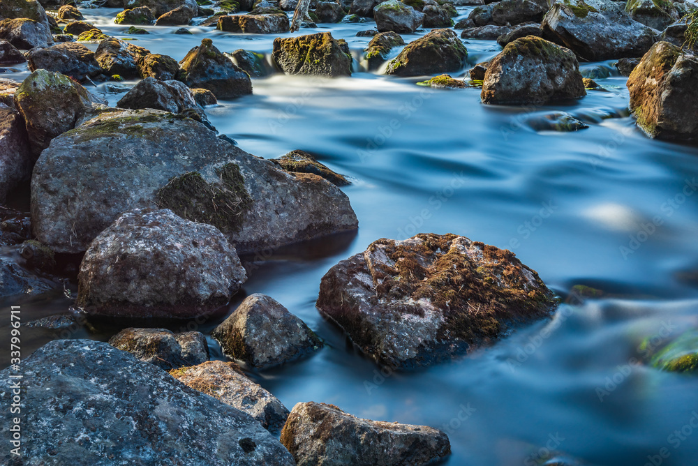 Rushing water with long shutter speed on the camera, between rocks in the Swedish valley during the spring. Rushing water with long shutter speed on the camera, between rocks in the Swedish valley during the spring.