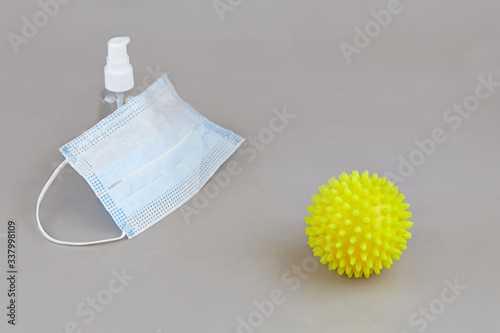 Protection from coronavirus: medical mask, disinfecting gel on a grey background.