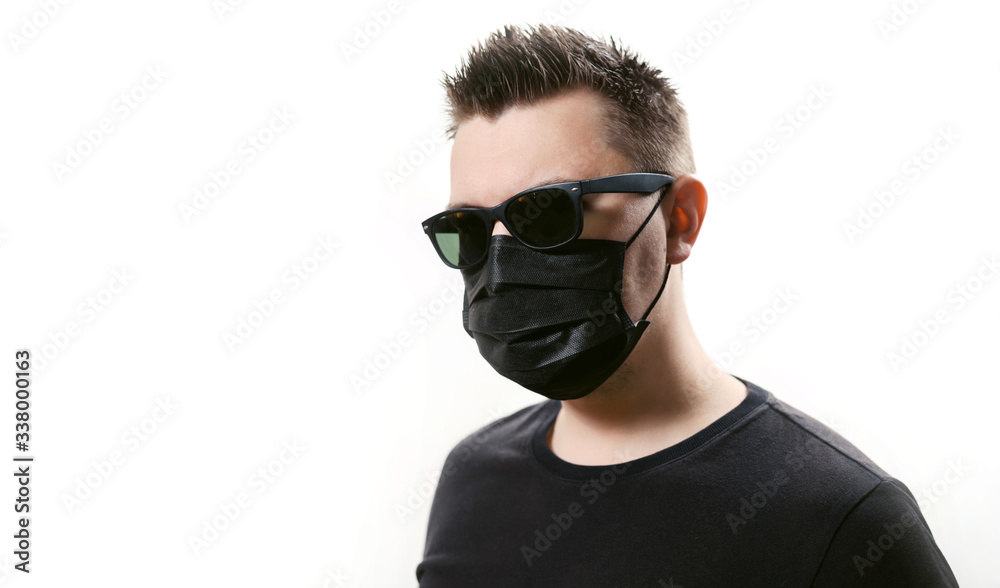 Closeup man in sunglasses in disposable medical mask isolated on a white background. Covid-19 coronavirus epidemic. Quarantine and self-isolation mode to save the population. Closeup man in sunglasses in disposable medical mask isolated on a white background. Covid-19 coronavirus epidemic. Quarantine and self-isolation mode to save the population.