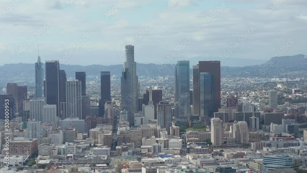 AERIAL: Slow Side Shot of Downtown Los Angeles Skyline with Warehouse Art Distrct in Foreground with Blue Sky and Clouds AERIAL: Slow Side Shot of Downtown Los Angeles Skyline with Warehouse Art Distrct in Foreground with Blue Sky and Clouds