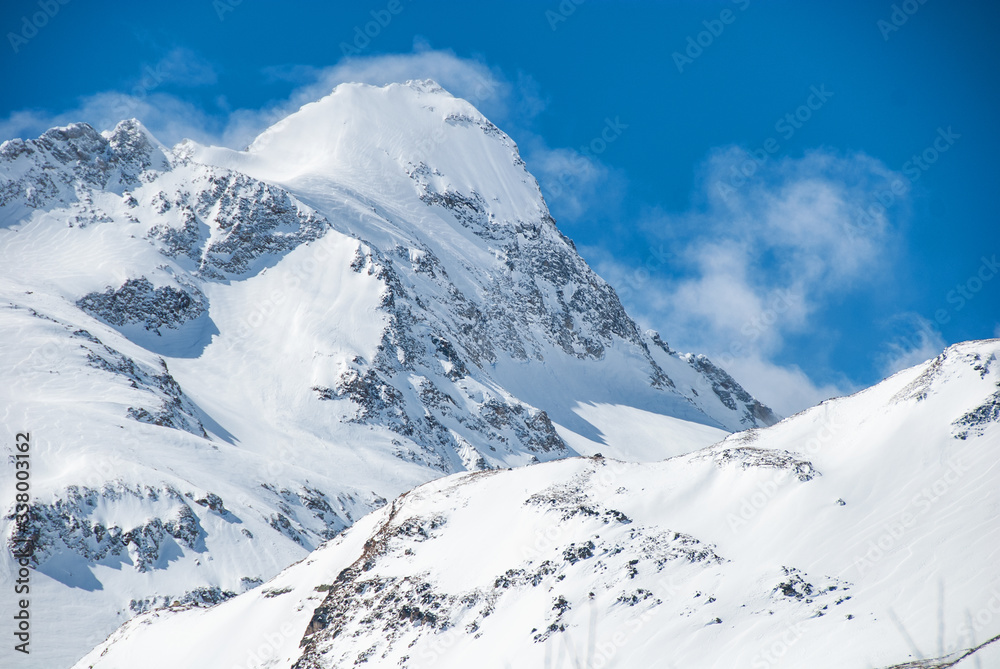 Mountain peak with snowstorm clouds on the ridge. Alpine winter view