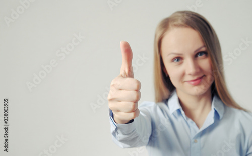 woman shows thumb up. good, positive mark and result gesture from pretty girl. well done concept