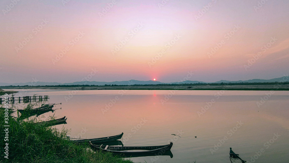 Sunset on the river. Boats standing near the coast.