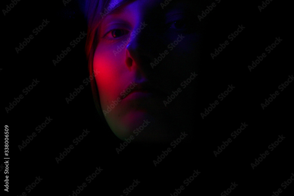 Dark portrait of a girl in color lighting