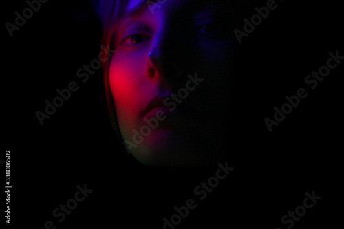 Dark portrait of a girl in color lighting