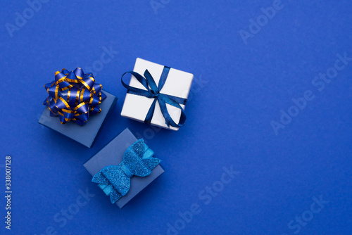 Wall Mural blue gift boxes with gold bow - top view - on classic blue background, copy spac
