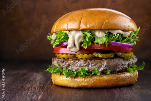 Beef burger with special pepper mayonnaise sauce on wooden table