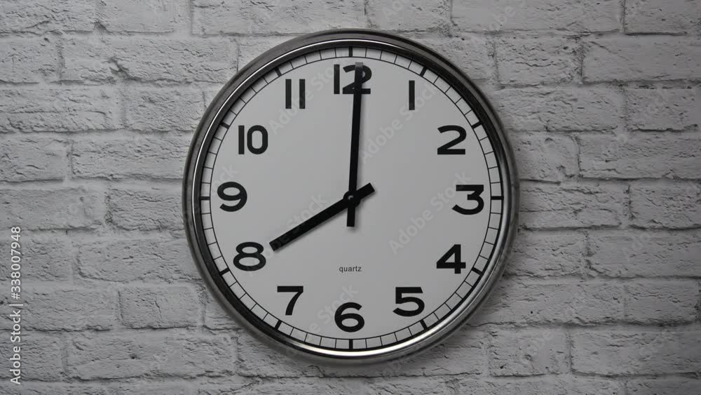 The Time On The Clock Eight. Clock With The Black Arrows With The Arabic Numerals On An White Brick Wall Background. The Time On The Clock Eight. Clock With The Black Arrows With The Arabic Numerals On An White Brick Wall Background.