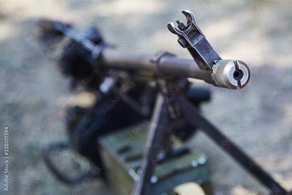 Russian machine gun stands on the ground. Focus on the gun barrel Russian machine gun stands on the ground. Focus on the gun barrel
