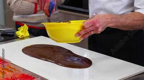 Tempering melted chocolate on table. Process of making handmade candies photo